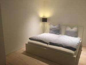 a bed with white sheets and pillows in a room at Appartement Burgblick in Harburg