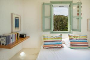 a bedroom with a bed with a window and books at Casa Xyla-sunset view villa in Melissaki