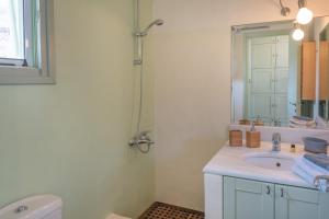 a white bathroom with a sink and a shower at Casa Xyla-sunset view villa in Melissaki