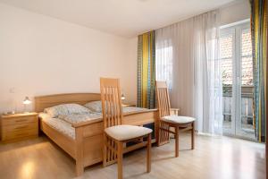 a bedroom with a bed and a desk and chairs at Ferienwohnungen Shamal in Reutin