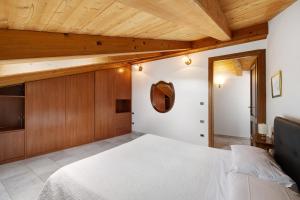 a bedroom with a white bed and wooden ceilings at Maison Noris in Finale Ligure