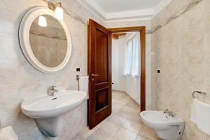 a bathroom with a sink and a mirror and a toilet at Maison Noris in Finale Ligure +14 photos