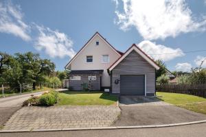 a white house with a garage on a street at Ferienwohnung Schneider in Blaubeuren