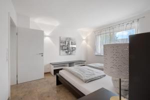 a bedroom with a bed and a desk and a window at Ferienwohnung Schneider in Blaubeuren