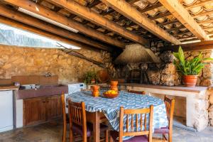 a kitchen with a table with chairs and a stove at Can Gallot De Punxuat - Pool in Algaida