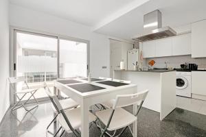 a white kitchen with a white table and chairs at Albalat Tarongers in Albalat de Taronchers