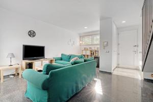 a living room with a blue couch and a tv at Albalat Tarongers in Albalat de Taronchers