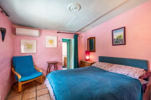 a bedroom with a blue bed and a blue chair at El Nido holiday cottage with pool in Órgiva +20 photos