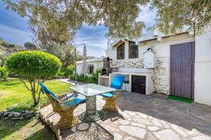 a patio with a table and chairs in front of a house at El Nido holiday cottage with pool in Órgiva