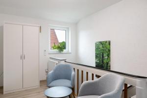 a staircase with two chairs and a window at Ferienwohnung Rhön-Kutscher in Buttlar