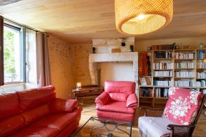 a living room with a red chair and a couch at Gite des Bois du Charme in Chalais