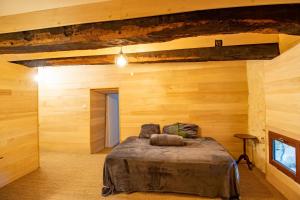 a bedroom with a bed in a room with wooden walls at Gite des Bois du Charme in Chalais