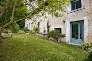 an empty yard in front of a house with a blue door at Gite des Bois du Charme in Chalais