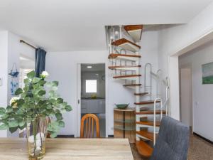 a dining room with a wooden table and a spiral staircase at Villa Mi Capricho by Interhome in Calafell