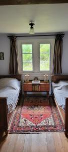 a room with two beds and a table and two windows at Historisches Bahnwärterhaus in Gremmelsbach