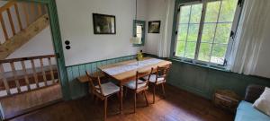 a dining room with a wooden table and chairs at Historisches Bahnwärterhaus in Gremmelsbach +23 photos