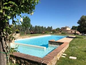 a swimming pool in a yard with a retaining wall at Appartamento Pino in Trequanda
