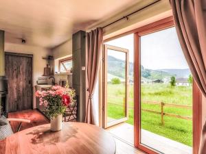 a room with a table with a vase of flowers at Chalet Boutique Tiny House by Interhome in Rothenthurm