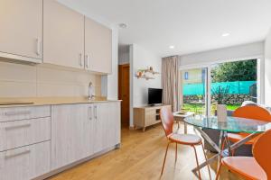 a kitchen with a glass table and orange chairs at 4 Jardin- Puerto Chico in Llanes