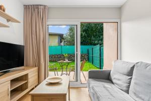 a living room with a couch and a tv at 4 Jardin- Puerto Chico in Llanes