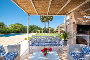 a patio with chairs and a table with flowers on it at Abatzer in Ciutadella