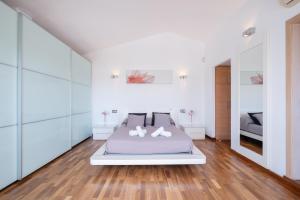 a white bedroom with a bed and wooden floors at Abatzer in Ciutadella +27 photos