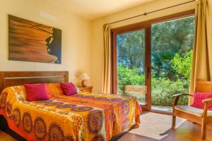 a bedroom with a bed and a large window at Sa Muntanya panorama in Santa Eularia des Riu +30 photos