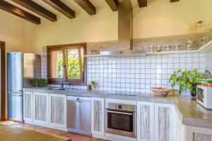a kitchen with a sink and a refrigerator at Sa Muntanya panorama in Santa Eularia des Riu