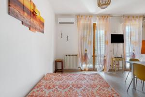 a living room with white walls and a red rug at Coral House Viareggio in Viareggio