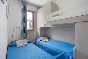 two beds in a small room with blue sheets at Coral House Viareggio in Viareggio