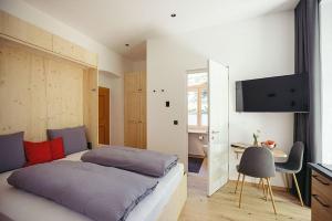 a bedroom with a bed and a desk and a television at Freienfeldhof Gala in Lagundo