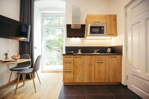 a kitchen with wooden cabinets and a sink and a table at Freienfeldhof Gala in Lagundo