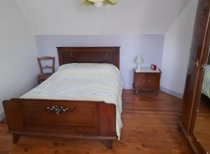a bedroom with a wooden bed with a wooden floor at La Maisonnette in Goulles