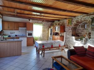a kitchen and a living room with a table in it at La Maisonnette in Goulles