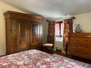 a bedroom with a bed and a dresser and a window at Villa Gioia sui colli Euganei in Torreglia