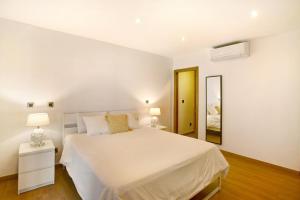 a white bedroom with a bed and a mirror at Villa Tauro 31 in Mogán +36 photos