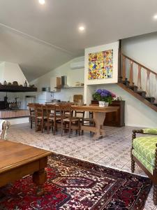 a living room with a dining table and a kitchen at Villa Gioia sui colli Euganei in Torreglia