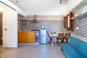 a kitchen with a blue couch and a table at Casamari nel centro di Marzamemi in Marzamemi +15 photos