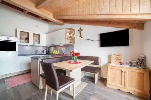 a kitchen with a table and chairs and a television at Sagschneiderhof Red Delicious in Plaus +6 photos