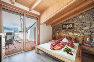 a bed in a room with a stone wall at Sagschneiderhof Red Delicious in Plaus