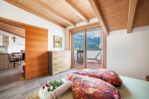 a room with a bed and a desk with a view at Sagschneiderhof Red Delicious in Plaus