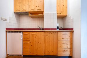 a kitchen with wooden cabinets and a sink at Lindenhof Apt 6 in Vandoies +14 photos