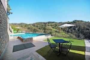 a patio with a table and chairs and a pool at Baia di Campo in Campomorone