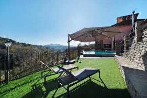 a patio with a chair and an umbrella next to a house at Baia di Campo in Campomorone