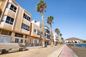 a street with palm trees in front of a building at Ocean Side Arinaga in Arinaga