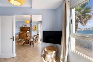 a living room with a television and a dining room with a table at Ocean Side Arinaga in Arinaga