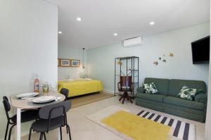 ein Wohnzimmer mit Sofa und Tisch in der Unterkunft Excelente Studio in Loulé + 14 Fotos
