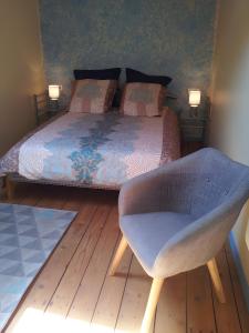 a bedroom with a bed and a chair at La Grange De Vauviault in Bressuire