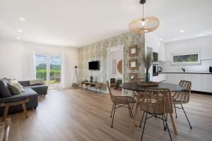 a living room and dining room with a table and chairs at Casa da Vinha in Óbidos