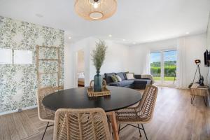 a living room with a table and chairs and a couch at Casa da Vinha in Óbidos